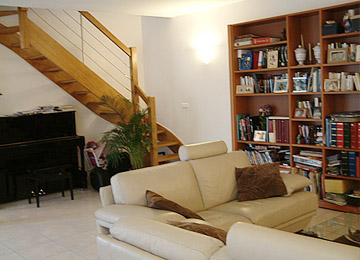 Visuel du séjour avec l'escalier en coin