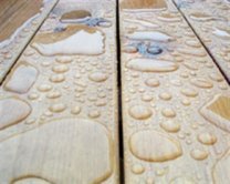 Visuel d'un plancher extérieur en bois, revêtu de gouttes de pluie.